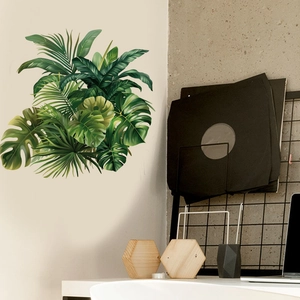 Detail of tropical monstera leaf wall stickers on a light wall above a modern home desk