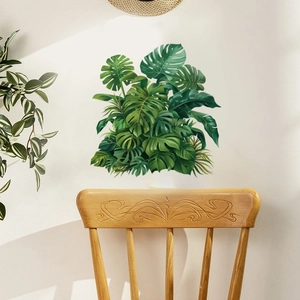 Tropical monstera leaf wall decals in a Nordic living room with a wooden chair