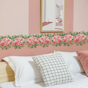 Détail de l'autocollant mural rose rose vigne appliqué horizontalement sur un mur de chambre