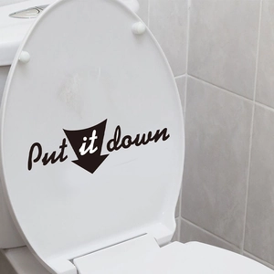 Détail du sticker mural noir imperméable Put It Down posé sur un abattant de WC blanc