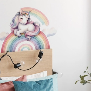 Close-up of a cartoon unicorn and rainbow wall sticker in a cozy kids bedroom setting