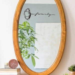 Detail view of black 'family' wall sticker with flower on a wooden frame mirror