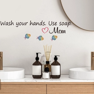 Detail of adhesive bathroom mirror sticker with Wash Your Hands text and fish motifs