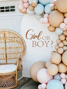 Gender reveal party backdrop featuring pastel balloon arch and Girl OR BOY decal sign