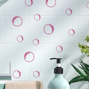 Detail view of pink bubble wall stickers on white tile wall in a modern bathroom