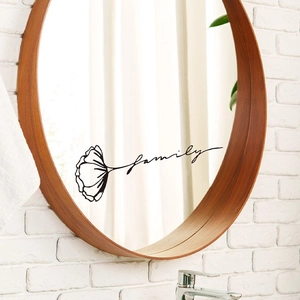 Family quote wall sticker with black flower design on a round bathroom mirror