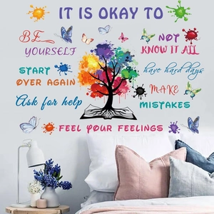 Close-up of colorful tree wall sticker with inspirational quotes above a bedroom headboard