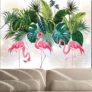Pink flamingo wall sticker with tropical palm leaves above a minimalist beige sofa