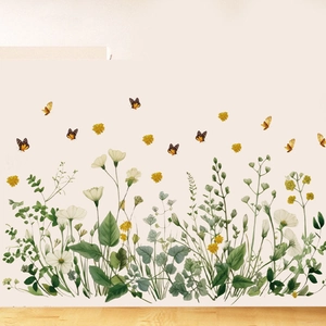 Close-up of realistic floral and orange butterfly wall stickers on a clean white wall