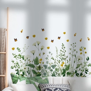 Detail of floral butterfly wall stickers with green leaves and yellow insects on white wall