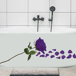 Close-up of purple rose stickers with petals on a white bathtub in a bathroom