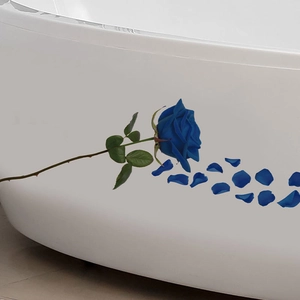 Detailed view of waterproof blue rose floral stickers applied to a white bathtub surface