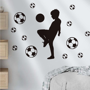Black vinyl wall decal featuring a boy playing soccer with multiple football patterns