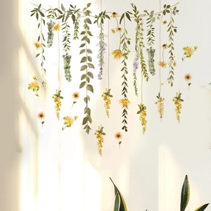 Detailed view of green leaf vines and yellow flower wall stickers on a white wall