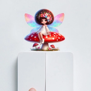 Detail of fairy wall sticker with rainbow wings sitting on a red mushroom