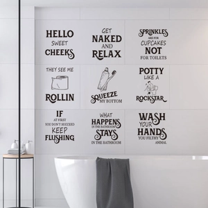 Close-up of 9 humorous black vinyl bathroom wall decals on a clean white tile wall