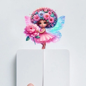 Close-up of a fairy wall sticker with floral crown and blue wings above a white wall switch