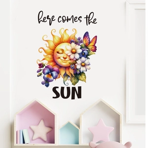 Detail of cartoon sun and daisy wall decal with 'here comes the SUN' text on a white wall