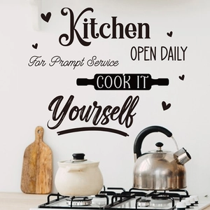 Detail of creative black vinyl kitchen wall decal with artistic text on a white wall