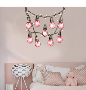 Pink light bulb wall decals with black strings creating a cozy nursery room ambiance