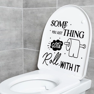 Detail of humorous roll paper quote decal on a white toilet lid in a modern bathroom