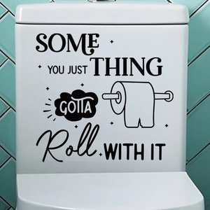Modern bathroom decor showing a black toilet sticker with phrase and roll paper illustration