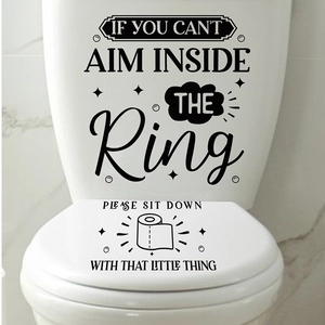 Detail showing minimalist black PVC toilet lid stickers with humorous text in a clean bathroom