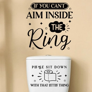 Detail of black vinyl bathroom decal with humorous quotes on wall and toilet tank