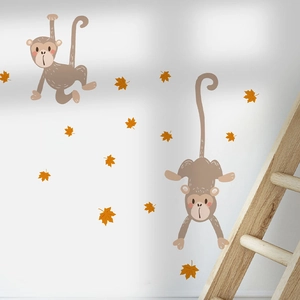 Cartoon monkey wall stickers with orange maple leaves on a white wall in a cozy room decor