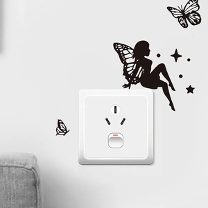 Close-up of black butterfly and fairy PVC wall sticker around a white power socket