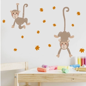 Detailed view of removable cartoon monkey wall stickers and maple leaves on a white wall