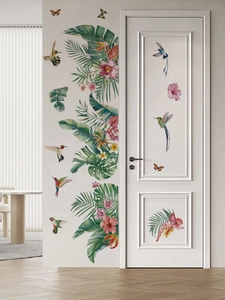 Detail of tropical wall stickers featuring green leaves, hummingbirds and flowers on a white door