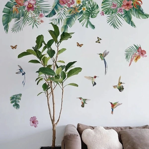 Detail of tropical monstera leaves and hummingbird wall stickers in a living room set