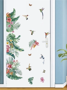 Detailed view of tropical hummingbird and floral wall stickers on a white interior door