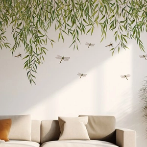 Detail view of green bamboo leaves and dragonflies wall decal on a white surface