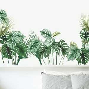 Realistic tropical monstera and palm leaf wall decals in a serene bedroom setting