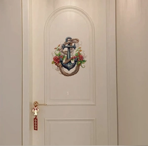 Vue détaillée du sticker mural ancre nautique et fleurs sur une porte en bois blanc