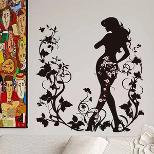 Détail de l'autocollant mural silhouette de fille à fleurs noires sur mur de salon gris clair