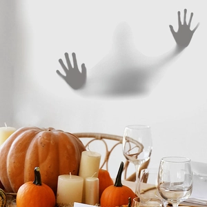 Close-up of 3D ghost hand wall sticker in a decorated Halloween dining room setting