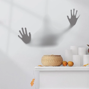 Detailed view of spooky grey ghost window cling on white wall with autumn decor