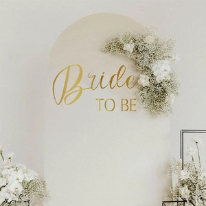 Elegant gold Bride to Be wall decal on arched backdrop with white floral accents