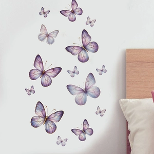 Detail of 3D lilac and blue butterfly wall stickers with gold edges in a bedroom setting