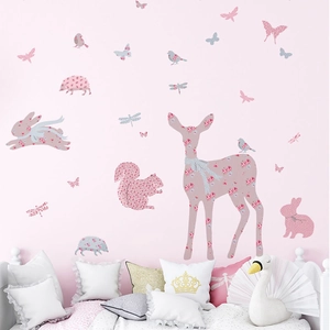 Detail view of pink floral cartoon forest animal wall stickers in a cozy nursery room