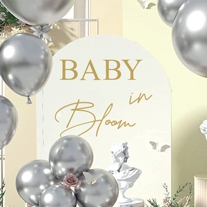 Adesivo murale dorato BABY in Bloom per decorazioni festa su sfondo crema ad arco