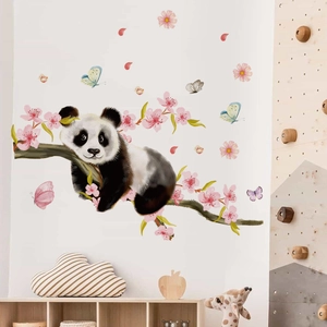 Detail view of cartoon panda and cherry blossom wall sticker in a cozy nursery setting