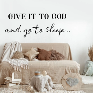 Close-up of 'GIVE IT TO GOD' inspirational wall decal in a cozy bedroom setting