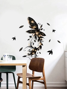 Detail of black butterfly wall sticker with gold dust effect in a modern dining room