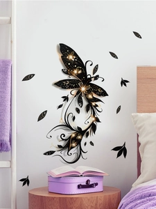 Detail of black and gold butterfly wall decal with floral accents in bedroom setting
