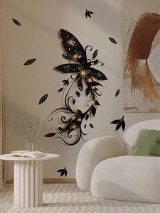Detailed view of black and gold butterfly wall stickers in a cozy modern living room setup