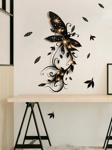 Detailed view of black and gold butterfly wall sticker on a minimalist white background